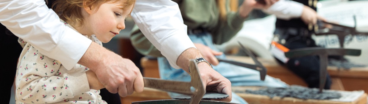 Ein Mann hilft einem Kind bei der arbeit an einer Schieferntafel.