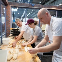 3 Bäcker:innen rollen Baguettes